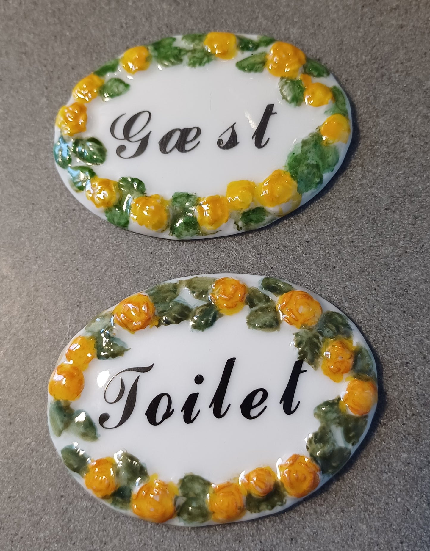 Toiletskilt med blomster.