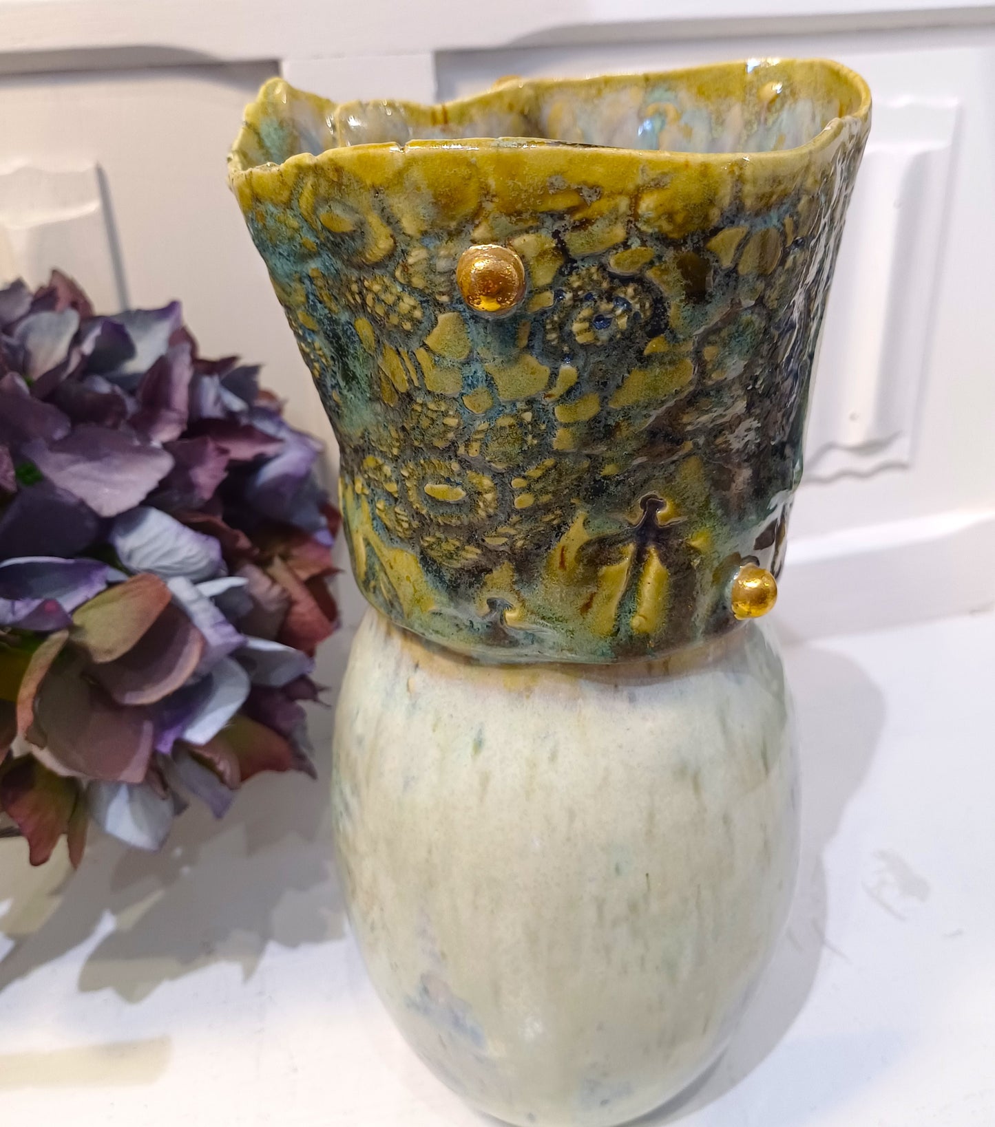 Marmoret vase med guld knopper.