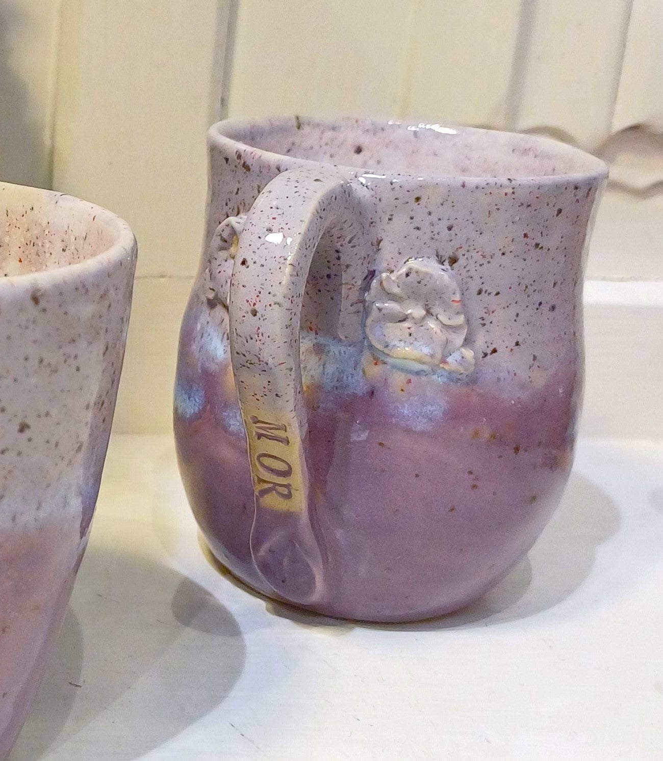 Pink keramik kopper med skrift.