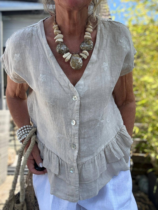 Sort hørbluse med stjernebroderi og knapper.