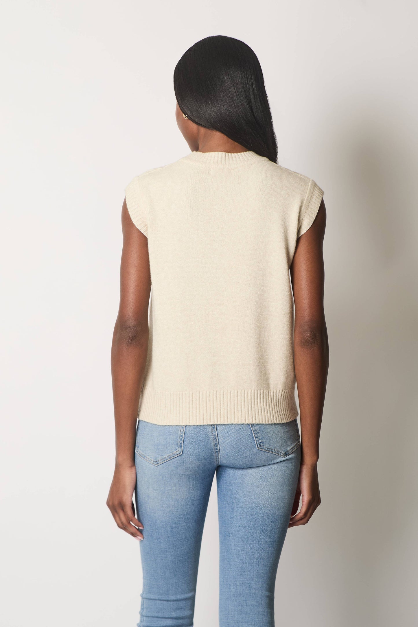 Ærmeløs kabelstrikket jumper.