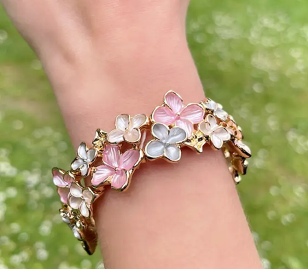 Farverigt blomsterarmbånd i lyserød nuancer med elastik.