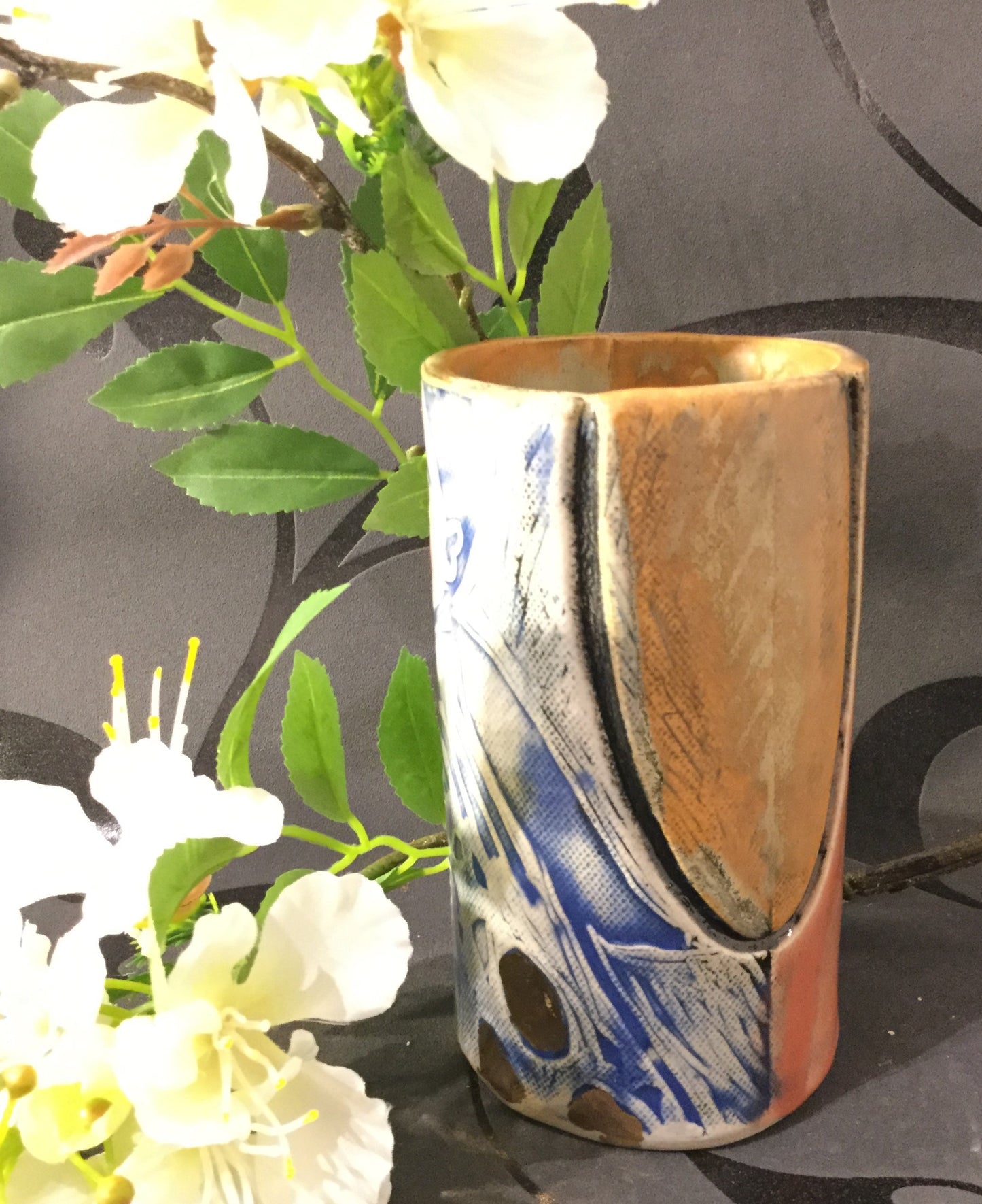 Cylindervase i blå og koral farver.