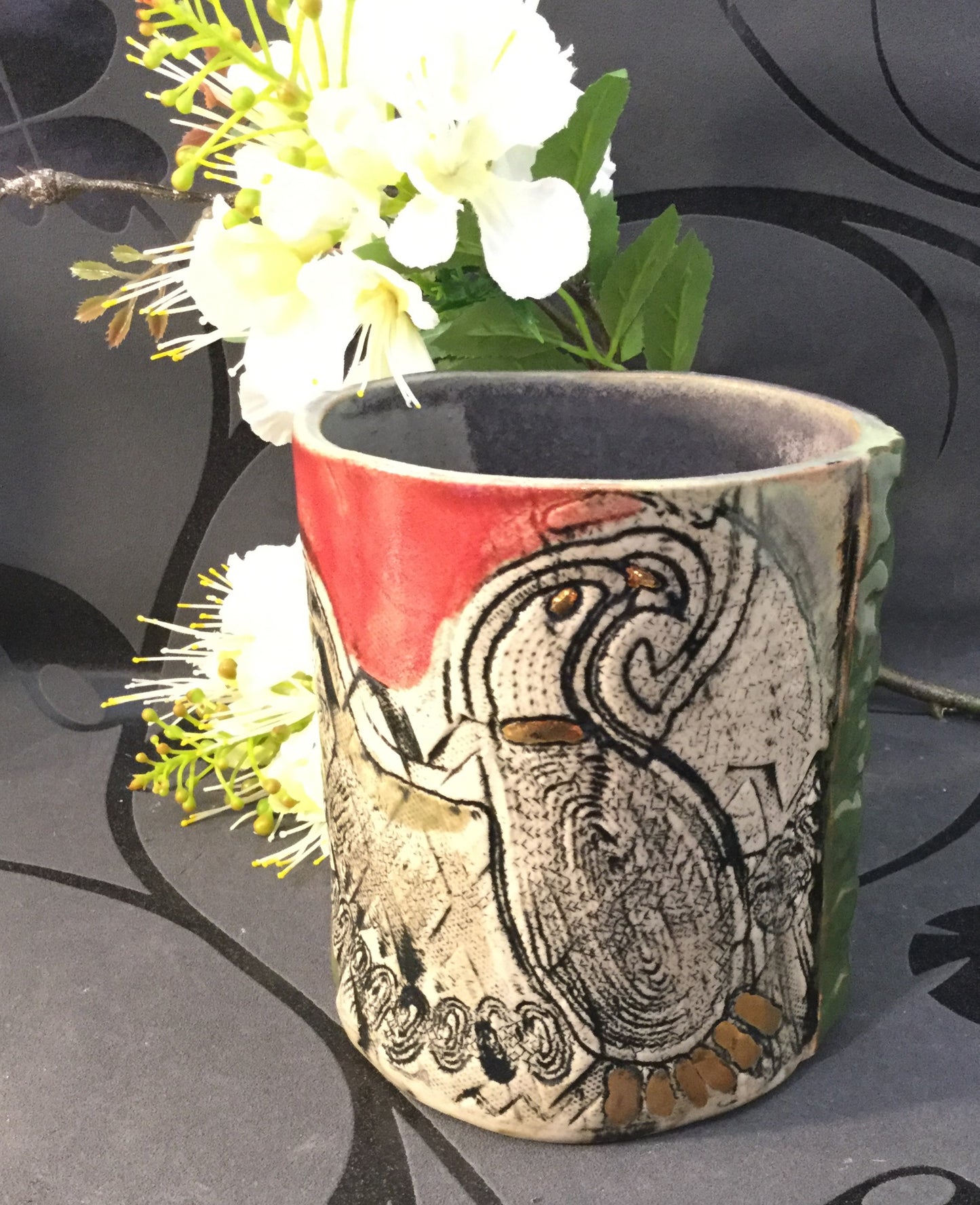 Cylindervase i rød og grøn med ørnemotiv.