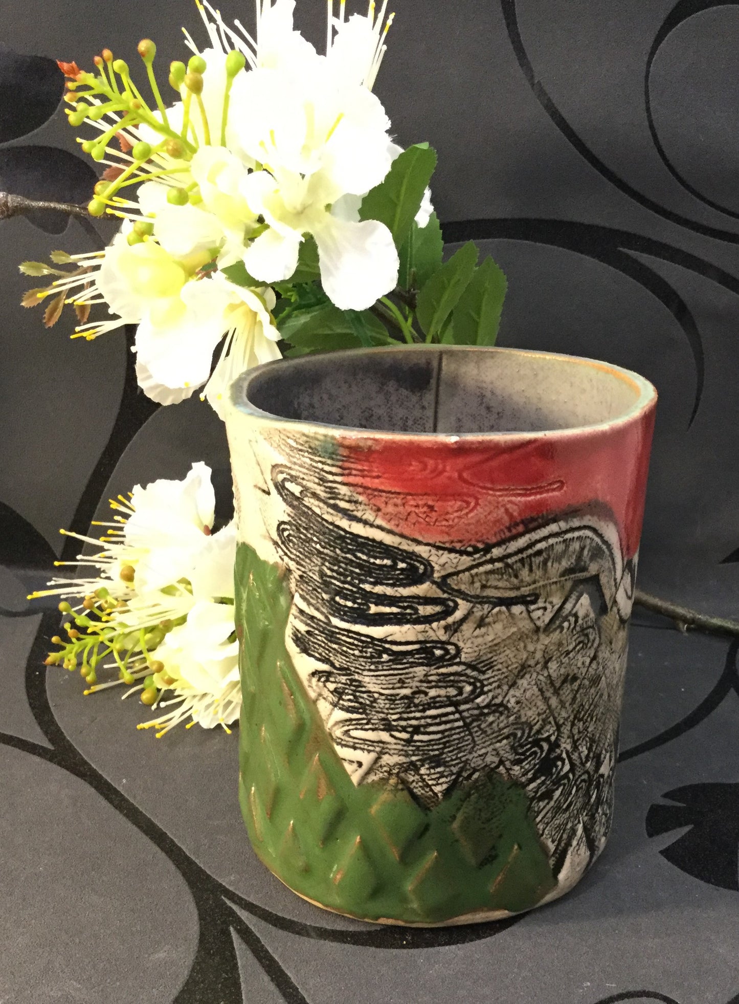 Cylindervase i rød og grøn med ørnemotiv.