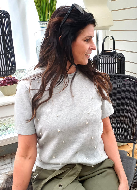 Grå bluse med perledetaljer.