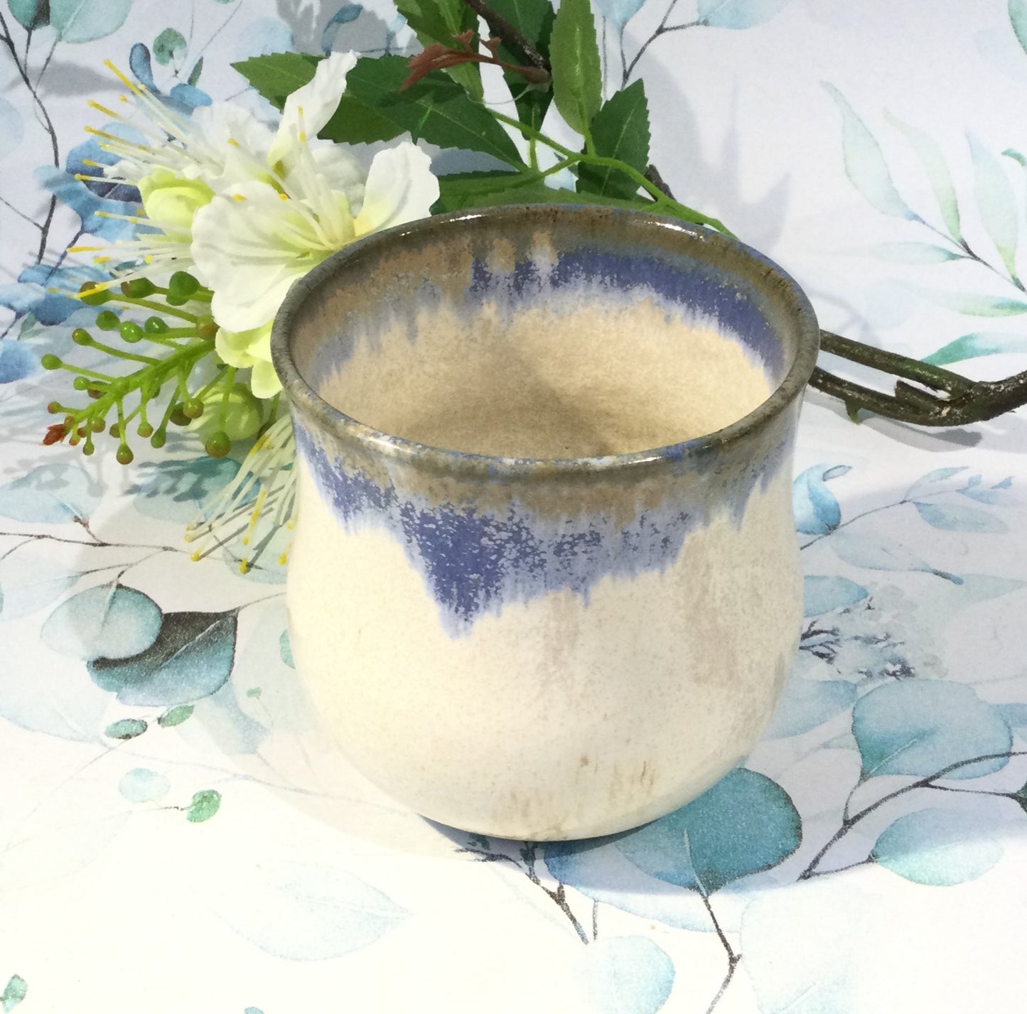 Latte kop i hvid keramik med farvede kant.