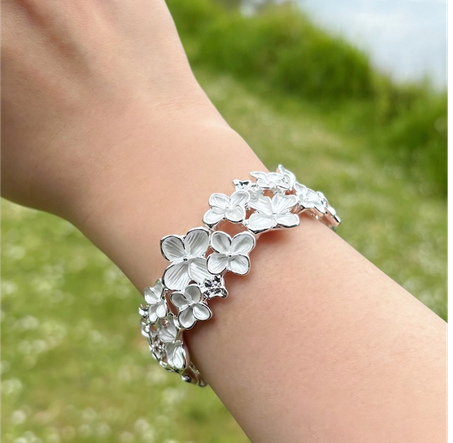 Farverigt blomster armbånd i hvid nuancer med elastik.