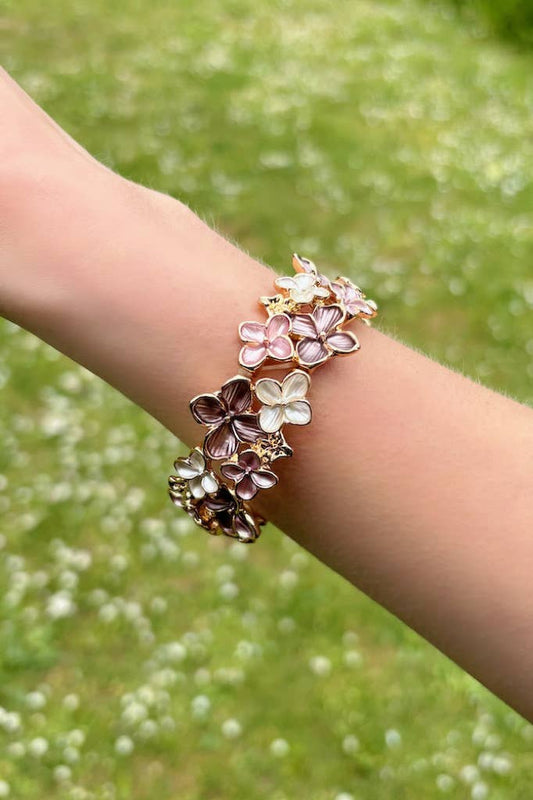 Farverigt blomsterarmbånd i brune nuancer med elastik.
